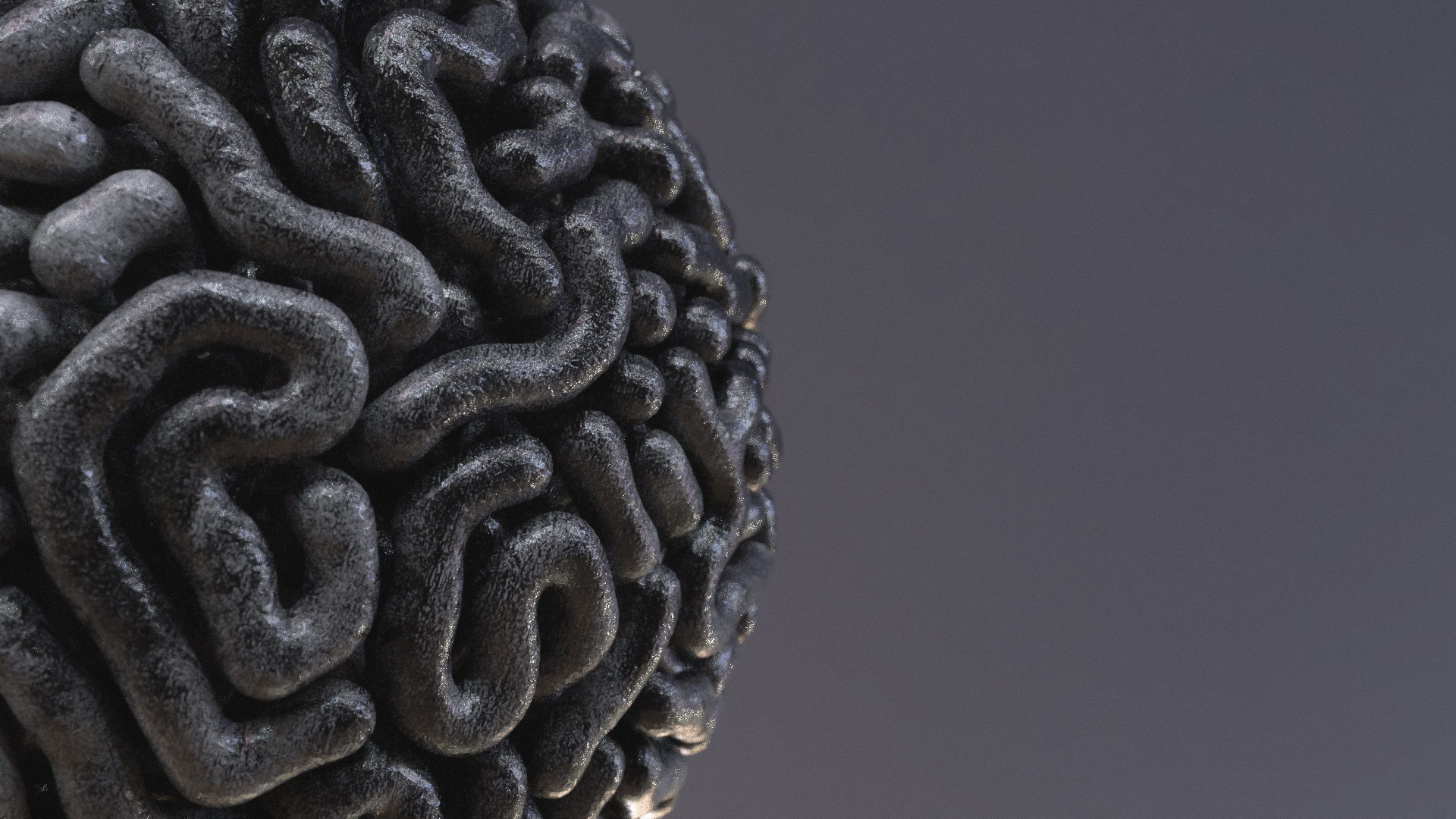 Metallic worm-like shapes packed into a perfect hemisphere on the left of the frame.